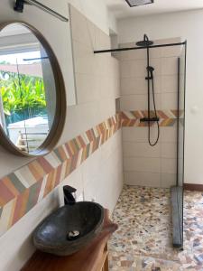 ein Bad mit einem schwarzen Waschbecken und einem Spiegel in der Unterkunft Studio 42 in Petit-Bourg