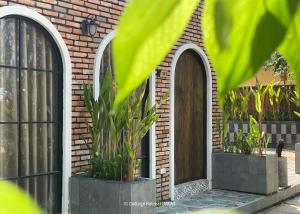 a brick building with two arched doors and plants at Cottage Retreat DALAT in Da Lat +21 photos