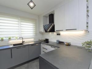una cocina con gabinetes blancos y una encimera gris en Holiday Home Id&la by Interhome, en Brodarica