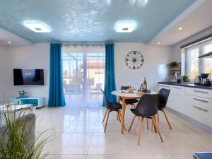a kitchen with a table and chairs and a clock at Holiday Home Villa Fenix by Interhome in Žminj