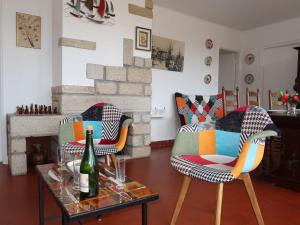 a living room with two chairs and a table with a bottle of wine at Holiday Home Ar Goualaniged by Interhome in Esquibien