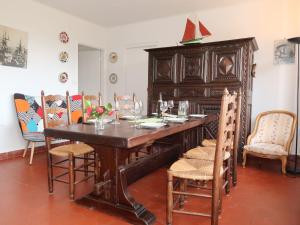 a dining room with a wooden table and chairs at Holiday Home Ar Goualaniged by Interhome in Esquibien