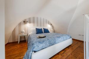 ポリニャーノ・ア・マーレにあるOltremareのベッドルーム1室(青い掛け布団付きのベッド1台付)