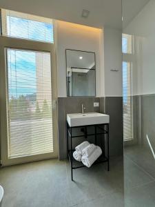 a bathroom with a sink and a mirror at Green Condo Hotel Palase in Palasë