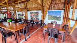 uma sala de jantar com mesas e cadeiras de madeira em Finca Hotel La Linda em Quimbaya