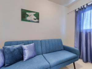 Sofá azul en la sala de estar con ventana en Apartment Villa Amra-5 by Interhome, en Poreč