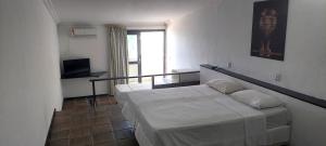 1 dormitorio con 2 camas y TV en Santorini Praia Hotel en Natal
