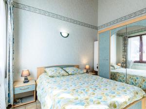 1 dormitorio con 1 cama grande y espejo en Holiday Home Lutins 5 by Interhome, en Les Mathes