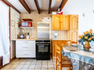 una cocina con armarios de madera y una mesa con mesa. en Holiday Home Lutins 5 by Interhome, en Les Mathes