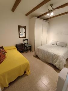 a bedroom with two beds and a chair at Rinconcito en Aguamarga in Agua Amarga