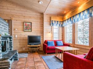 a living room with a fireplace and a tv at Holiday Home Villa paasisalo by Interhome in Siilinjärvi