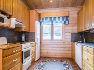 uma cozinha com armários de madeira e uma janela em Holiday Home Villa paasisalo by Interhome em Siilinjärvi