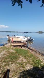 a boat sitting on the shore of a body of water at Pousada belo sol in São Pedro da Aldeia