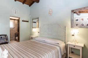 1 dormitorio con 1 cama, 2 mesas y espejo en B&B Al Vecchio Forno en Montepulciano