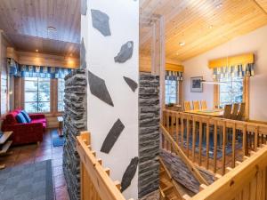 a living room and dining room with a stone wall at Holiday Home Villa paasisalo by Interhome in Siilinjärvi