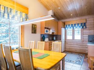 uma cozinha e sala de jantar com uma mesa de madeira e cadeiras em Holiday Home Villa paasisalo by Interhome em Siilinjärvi