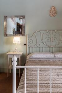 a bedroom with a bed with a mirror and a table at B&B Al Vecchio Forno in Montepulciano