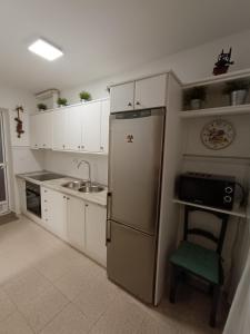 a kitchen with a refrigerator and a sink and a chair at Rinconcito en Aguamarga in Agua Amarga