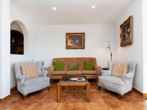 een woonkamer met een bank, 2 stoelen en een tafel bij Holiday Home Cataluña by Interhome in Vidreres