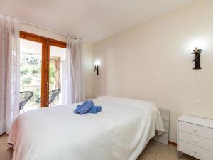 a bedroom with a white bed and a window at Holiday Home Escorpio-1 by Interhome in Tossa de Mar