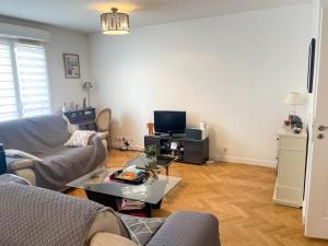 a living room with a couch and a table at Bel appartement spacieux / Proche Arena Paris Sud in Issy-les-Moulineaux