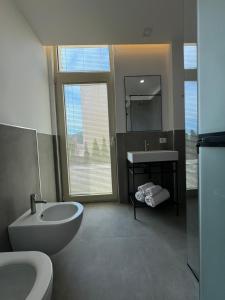 a bathroom with a tub and a sink and a toilet at Green Condo Hotel Palase in Palasë