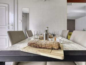 a dining room table with a table cloth on a wooden cutting board at Holiday Home bonnegrace by Interhome in Six-Fours-les-Plages