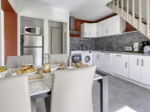 a kitchen with white cabinets and a table and chairs at Holiday Home bonnegrace by Interhome in Six-Fours-les-Plages
