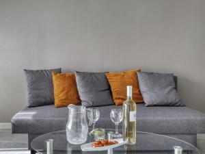 a couch with a bottle of wine and glasses on a table at Holiday Home bonnegrace by Interhome in Six-Fours-les-Plages +19 photos