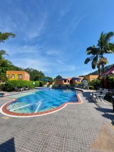 a swimming pool at a resort with palm trees at Hotel Campestre la Vega Inn in La Vega