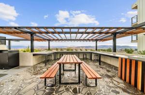 a patio with a table and benches on a building at Blackdiamond 504 - Beautiful, modern apartment - 2BdR, 2BthR in Tuggeranong