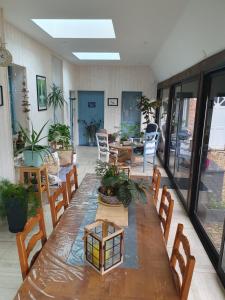 a room with a long wooden table and chairs at chez Marie et Patrick in Chaulnes +2 photos