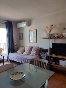 a living room with a bed and a glass table at Kione Vidalmar in Alcossebre