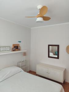 a white bedroom with a ceiling fan and a bed at Kione Vidalmar in Alcossebre