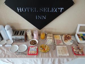 a table topped with food and drinks and food items at Select Inn in Río Grande