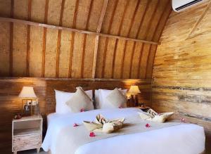 - une chambre avec un lit fleuri dans l'établissement Penida Green Palm Cottage, à Toyapakeh
