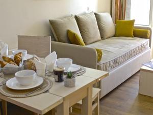sala de estar con sofá y mesa con platos en Apartment Village Cap Estérel - Le Village-79 by Interhome, en Agay - Saint Raphael