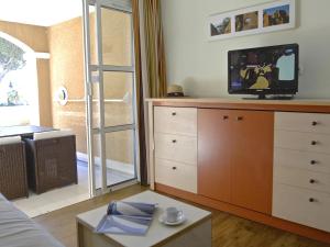 ein Wohnzimmer mit einem TV auf der Kommode in der Unterkunft Apartment Village Cap Estérel - Le Village-79 by Interhome in Agay - Saint Raphael