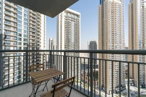 a balcony with two chairs and a table and some tall buildings at Lux BnB Dubai Creek Harbour BLVD Views in Dubai