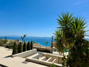a view of the ocean from a resort with palm trees at Green Condo Hotel Palase in Palasë