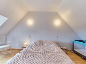 Un dormitorio con una cama grande y una silla. en Holiday Home Le Hameau Boudet by Interhome, en Barneville-Carteret