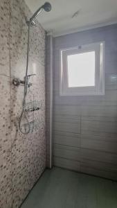 uma casa de banho com um chuveiro e uma janela. em Solar de Pisões em Marco de Canavezes