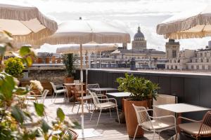 un patio con mesas y sillas y vistas a la ciudad en Hôtel Pilgrim, en París