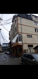 um edifício com um carro estacionado em frente em Apartman for 2-7 people em Ferizaj