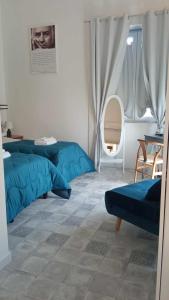 1 dormitorio con 2 camas azules y ventana en Residenza La Meridiana, en Briatico