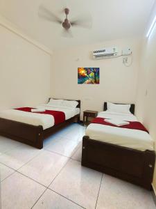 two beds in a white room with a ceiling at LE TOWNSHIP RESIDENCY in Pondicherry