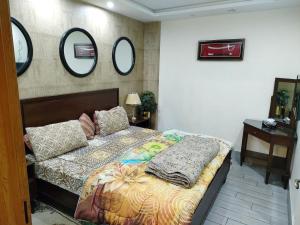 1 dormitorio con cama y espejos en la pared en Low budget beautiful apartment, en Lahore