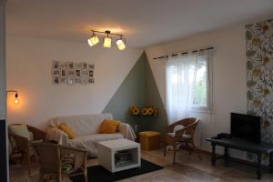 a living room with a couch and a tv at Le Petit Saule - Gîte entre Beauval et Chenonceau in Faverolles-sur-Cher