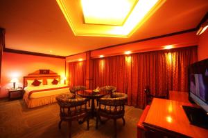 una camera d'albergo con letto, tavolo e sedie di The Surya, Cochin ad Angamaly