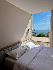 a bedroom with a bed with a view of the ocean at Green Condo Hotel Palase in Himare